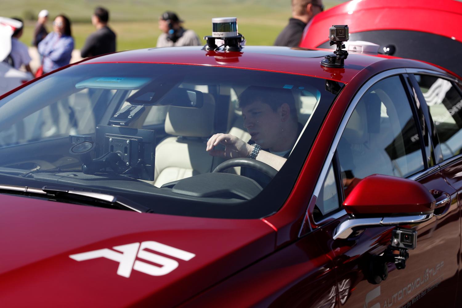 An engineer works on an AutonomouStuff Automated Research Development Vehicle during a self-racing cars event at Thunderhill Raceway in Willows, California, U.S., April 1, 2017. REUTERS/Stephen Lam - RC1C476426B0