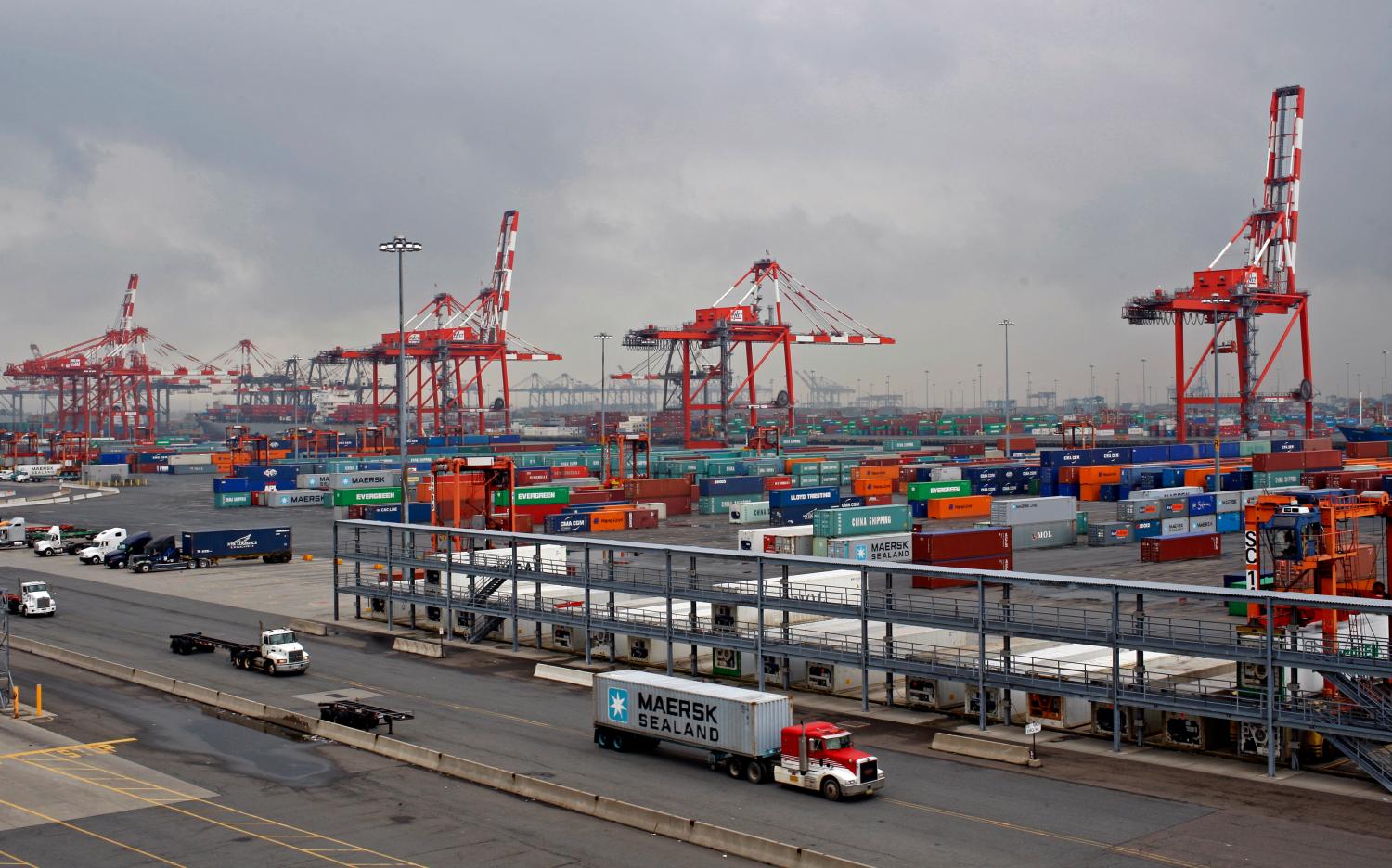 Trucks pass the Port Newark Container Terminal near New York City in Newark, New Jersey in this picture taken July 2, 2009. The port serving the densely populated Northeastern United States is but one of a string of U.S. ports on the Atlantic, Pacific, and Gulf coasts whose businesses have been thinned by this recession and a dramatic drop in consumer spending. Port Newark has seen a 30 percent drop in business from a year ago as a drop in sea trade has cost U.S. jobs, forced businesses into failure and slowed big-ticket capital spending. Picture taken July 2. To match FEATURE USA-ECONOMY/PORTS    REUTERS/Mike Segar    (UNITED STATES BUSINESS) - GM1E57G0A0C01