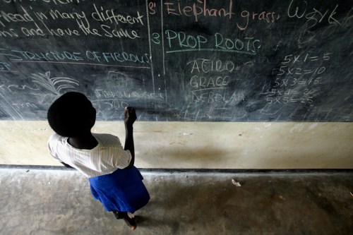 Grace Debroha, a 13-year-old orphan, writes the names of body parts on a chalkboard at St. Jude's Orphanage, outside Gulu, June 10, 2007.  REUTERS/Edward Ou (UGANDA) - GM1DVLMFNKAA