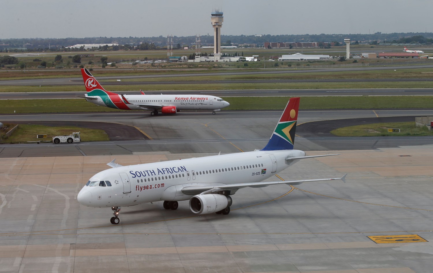 FILE PHOTO: A South African Airways Airbus A320-200 aircraft (bottom) arrives as a Kenya Airways Boeing 737-800 aircraft prepares to take off at the OR Tambo International Airport in Johannesburg, South Africa, March 8, 2017. REUTERS/Siphiwe Sibeko/File Photo - RC1E35E6C420