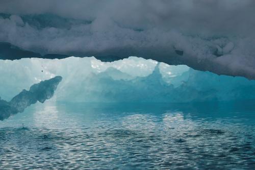 Water melts off of an iceberg as it floats in a fjord near Tasiilaq, Greenland, June 16, 2018.  REUTERS/Lucas Jackson - RC185A23C410