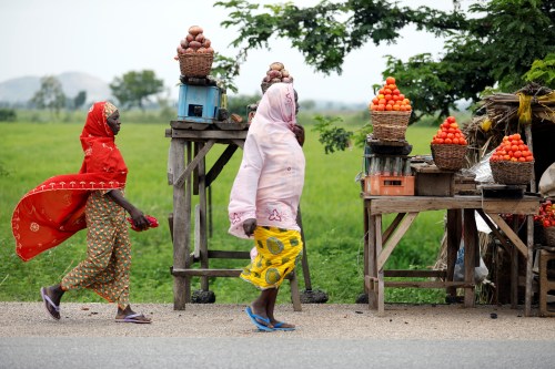 Women walk past tomatoes displayed for sale in baskets along the kano-Zaria road in Kano, northwest Nigeria August 21, 2017. Picture taken August 21, 2017. REUTERS/Akintunde Akinleye. - RC1B78CDB380
