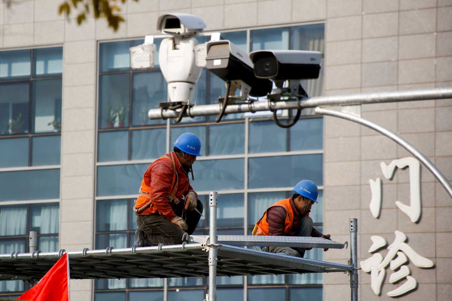 Men work on top of a scaffolding underneath CCTV surveillance cameras in Beijing, China, November 12, 2018. REUTERS/Thomas Peter - RC1287323E90
