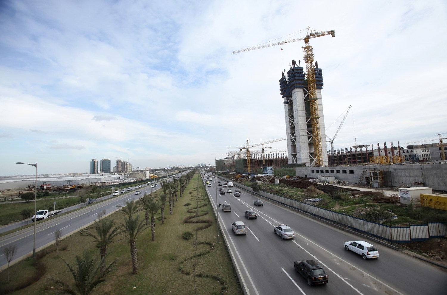 Vehicles pass by on a road near the construction site of the new Great Mosque, which is being built by the China State Construction Engineering Corporation (CSCEC), in Algiers, Algeria January 20, 2016. Algeria is turning to China for external financing for several infrastructure projects including a new $3.2 billion port as the North African OPEC state looks to weather the collapse in global oil prices. REUTERS/Ramzi Boudina - GF20000101188