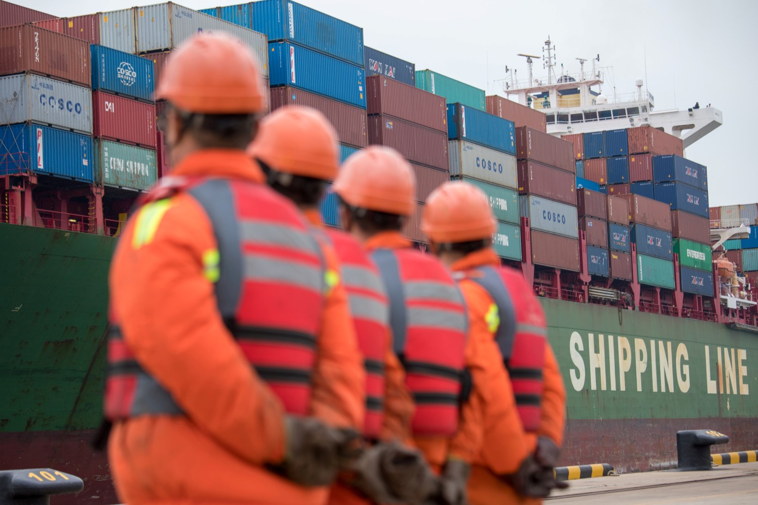 Workers look on as a cargo ship approaches a terminal at the port of Qingdao in Shandong province, China November 8, 2018. REUTERS/Stringer ATTENTION EDITORS - THIS IMAGE WAS PROVIDED BY A THIRD PARTY. CHINA OUT. - RC1BD4412950