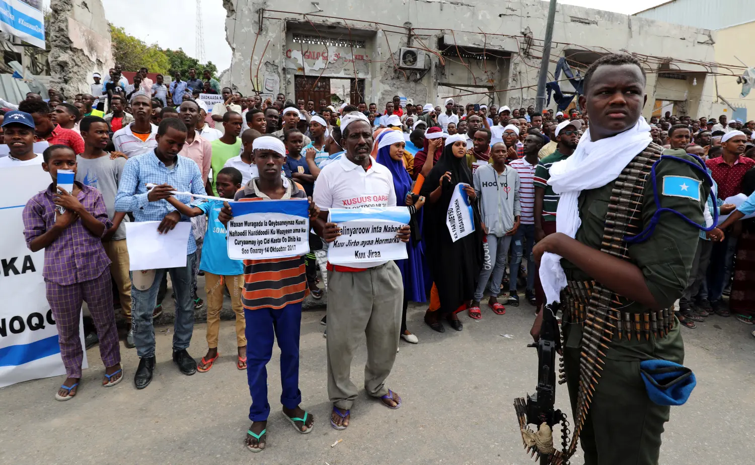 A security officer stands guard as civilians gather near the scene to mark the first anniversary of a terror attack, in the Hodan district of Mogadishu, Somalia. Photographer/Date: Feisal Omar/October 14, 2018.