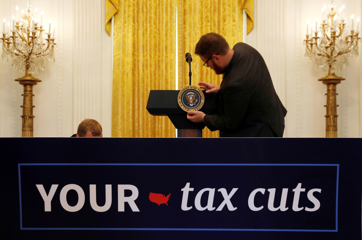 The Presidential seal is placed upon the lectern before U.S. President Donald Trump delivers remarks celebrating six months since his tax cuts victory at the White House in Washington, U.S., June 29, 2018. REUTERS/Kevin Lamarque - RC15EF5787B0