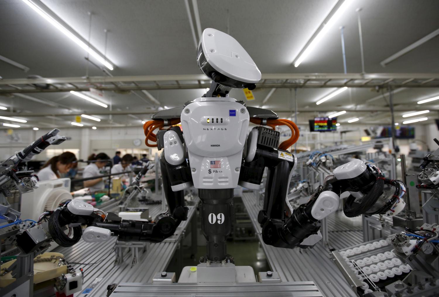 A humanoid robot works side by side with employees in the assembly line at a factory of Glory Ltd., a manufacturer of automatic change dispensers, in Kazo, north of Tokyo, Japan, July 1, 2015. Japanese firms are ramping up spending on robotics and automation, responding at last to premier Shinzo Abe's efforts to stimulate the economy and end two decades of stagnation and deflation. Picture taken July 1, 2015. REUTERS/Issei Kato TPX IMAGES OF THE DAY - GF10000147191