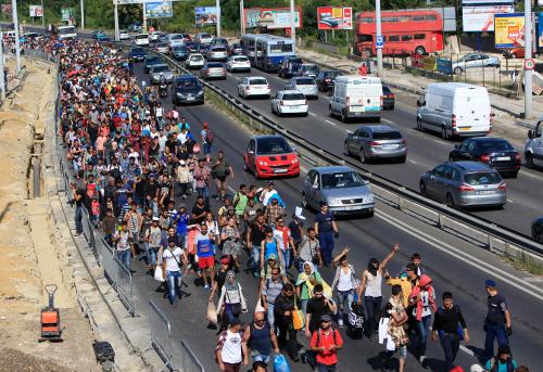 Migrants set off on foot for the border with Austria from Budapest, Hungary, September 4, 2015. Hundreds of migrants broke out of a Hungarian border camp on Friday and others set off on foot from Budapest as authorities scrambled to contain a migrant crisis that has brought Europe?s asylum system to breaking point. Hungary says it is enforcing European Union rules that it must register all migrants caught crossing Hungary?s borders, but thousands are refusing and demand they be allowed to continue their journey to western Europe from war and poverty in the Middle East, Africa and Asia. The European Union normally allows free movement between the 26 countries of its Schengen border-free zone, but its rules require asylum seekers to register in the first country where they arrive and remain until they are processed.    REUTERS/Bernadett Szabo  - LR2EB94125QO3