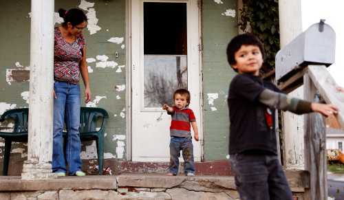 Lauranda Mignery (L) watches her sons, Kadin Mignery, 2,  (C) and Collin Mignery, 5, as they play on their front porch in St. Joseph, Missouri, U.S. November 15, 2016. Picture taken November 15, 2016.  To match Special Report USA-LEAD/TESTING    REUTERS/Whitney Curtis - RC1D32EE2110