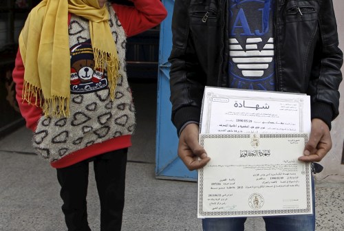 Younes Fekraoui, 26, who is an unemployed graduate, holds his degree certificates at a street at the impoverished Zhor neighborhood of Kasserine, where young people have been demonstrating for jobs since last week, January 28, 2016. REUTERS/Zohra Bensemra - GF10000288051