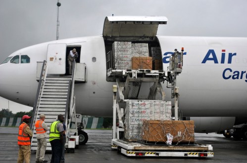 Workers are seen as the first consignment of U.S. Agency for International Development (USAID) medical equipment towards the fight against Ebola is offloaded at the Roberts International Airport in Monrovia, August 24, 2014. The World Health Organization (WHO) has warned that a decision by many transport companies to suspend services to Ebola-hit countries was leading to shortages of basic goods and foodstuffs. The USAID airlifted more than 16 tons of medical equipment and emergency supplies to the Liberian capital Monrovia on Sunday. Picture taken August 24, 2014. REUTERS/James Giahyue (LIBERIA - Tags: DISASTER SOCIETY HEALTH TRANSPORT) - GM1EA8P19PE01