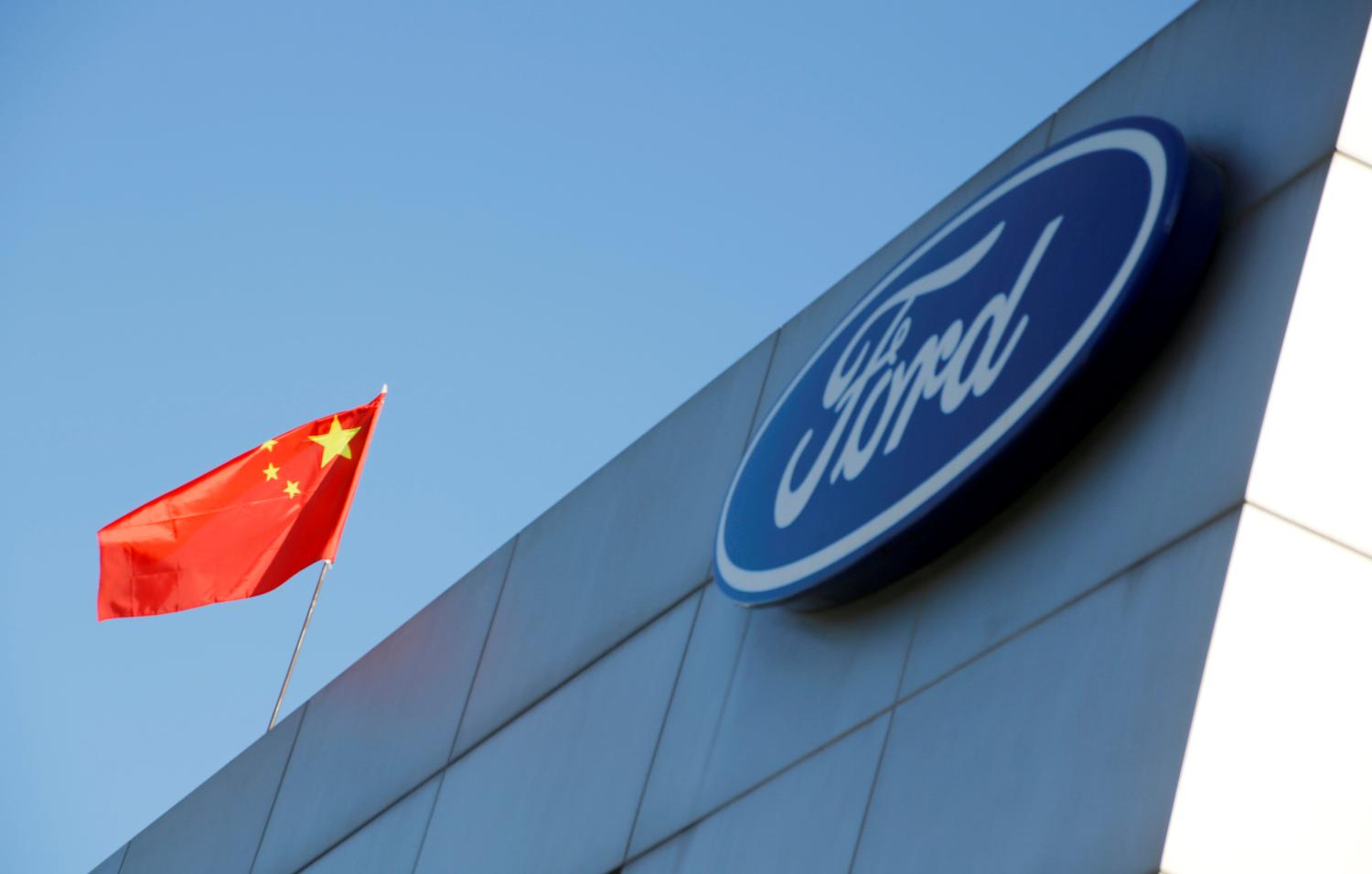 The Chinese national flag flies on the roof of a Ford car dealership in Beijing, China October 11, 2018. To match Exclusive CHINA-AUTOS/DEALERS. REUTERS/Thomas Peter - RC188C227800