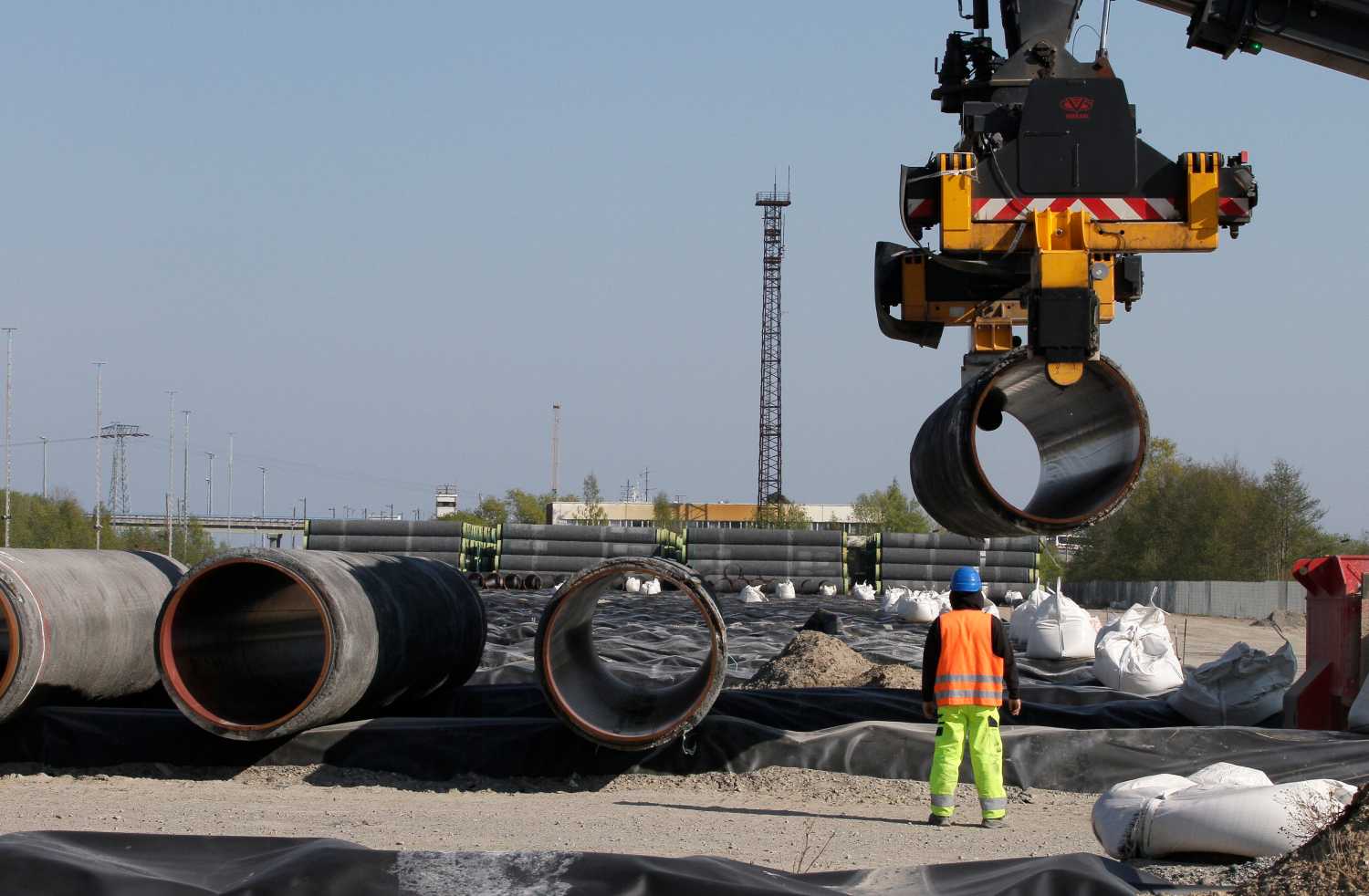 A worker watches as pipes are piled up at a storage area at French pipe coating company EUPEC in Sassnitz May 6, 2011. EUPEC is working to complete around 200,000 pipes for Nord Stream, which is building two 1,220km-long roughly parallel gas pipelines across the Baltic Sea from Russia to Germany with an overall annual capacity of 55 billion cubic metres (bcm).  REUTERS/Tobias Schwarz (GERMANY - Tags: ENERGY BUSINESS) - GM1E757035W01