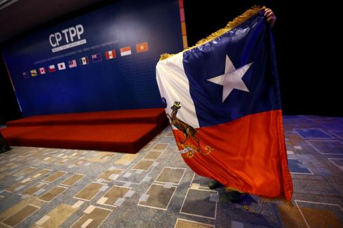A man arranges a Chilean flag during the signing agreement ceremony for the Trans-Pacific Partnership (TPP) trade deal, in Santiago, Chile March 8, 2018. REUTERS/Ivan Alvarado - RC191708E900