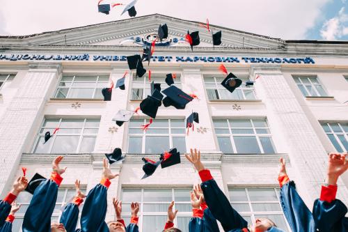 Students throwing graduation caps up in the air