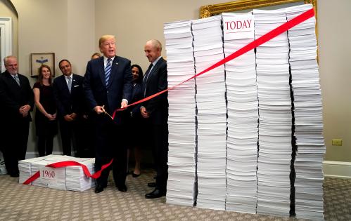 U.S. President Donald Trump cuts a red tape while speaking about deregulation at the White House in Washington, U.S., December 14, 2017. REUTERS/Kevin Lamarque - RC1D5597AAF0