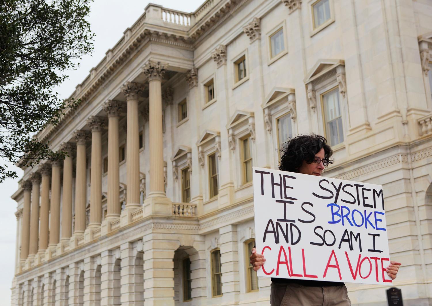 U.S. government furloughed worker Jamie holds a sign for representatives to read, as the government shutdown enters day nine, outside the U.S. Capitol House Chamber in Washington October 9, 2013.    REUTERS/Gary Cameron   (UNITED STATES - Tags: POLITICS BUSINESS CIVIL UNREST) - GM1E9AA02P701