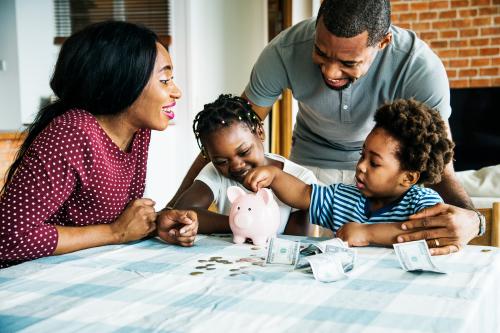 Family saving money to piggy bank