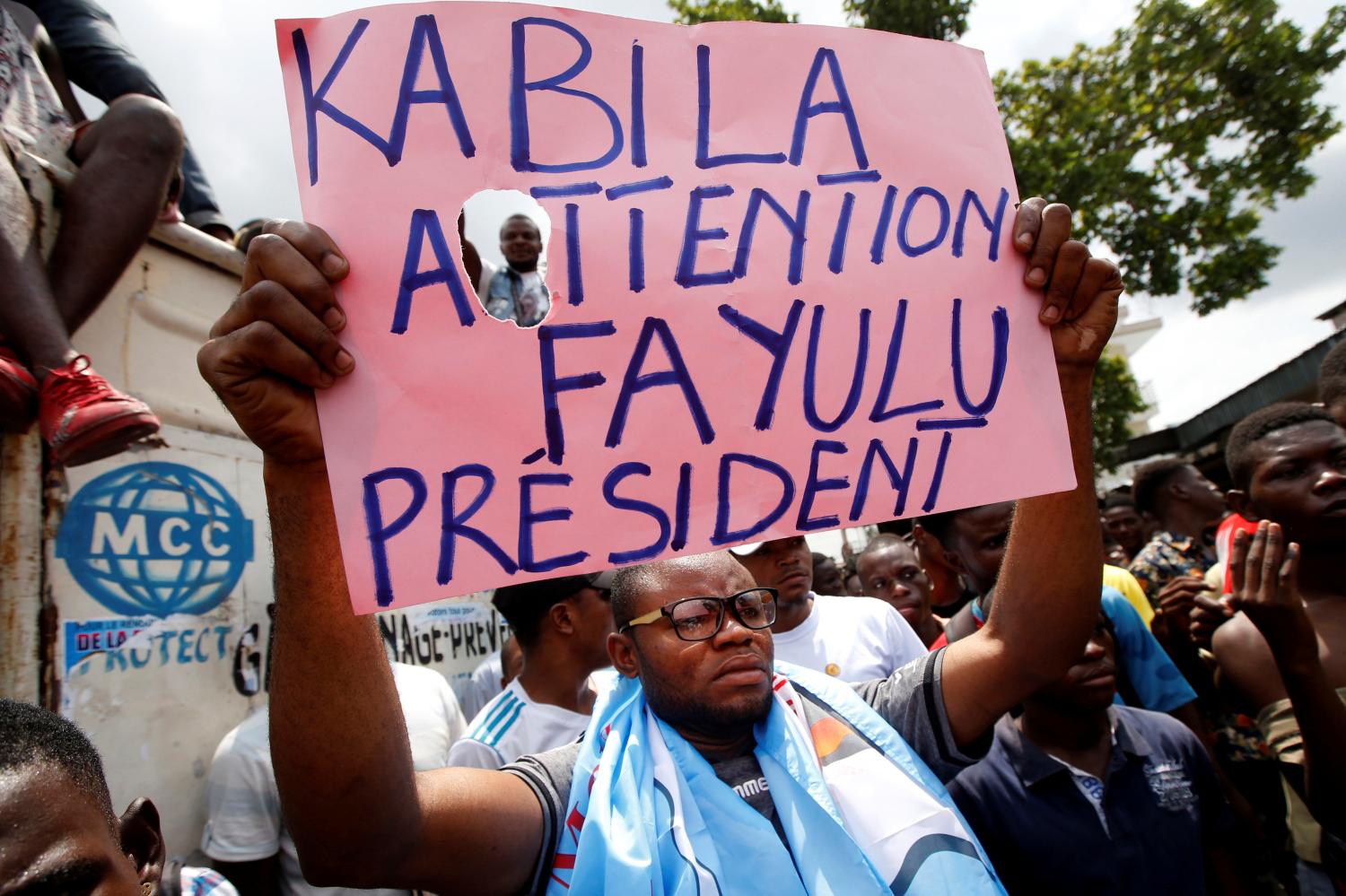 Supporters of the runner-up in Democratic Republic of Congo's presidential election, Martin Fayulu hold a sign before a political rally in Kinshasa, Democratic Republic of Congo, January 11, 2019. REUTERS/Baz Ratner - RC1F2DDA27B0