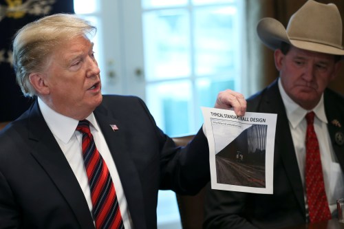 U.S. President Donald Trump shows a photo of a "typical" border wall design  during a "roundtable discussion on border security and safe communities" with state, local, and community leaders in the Cabinet Room of the White House in Washington, U.S., January 11, 2019. REUTERS/Leah Millis - RC1B9D0904A0