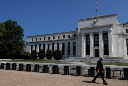A person walks past the Federal Reserve building in Washington, U.S., July 16, 2018. REUTERS/Leah Millis - RC15C50746E0