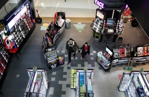 A man and a boy walk at a shopping center in Beijing, China December 14, 2018. REUTERS/Jason Lee - RC14A8CE2E40