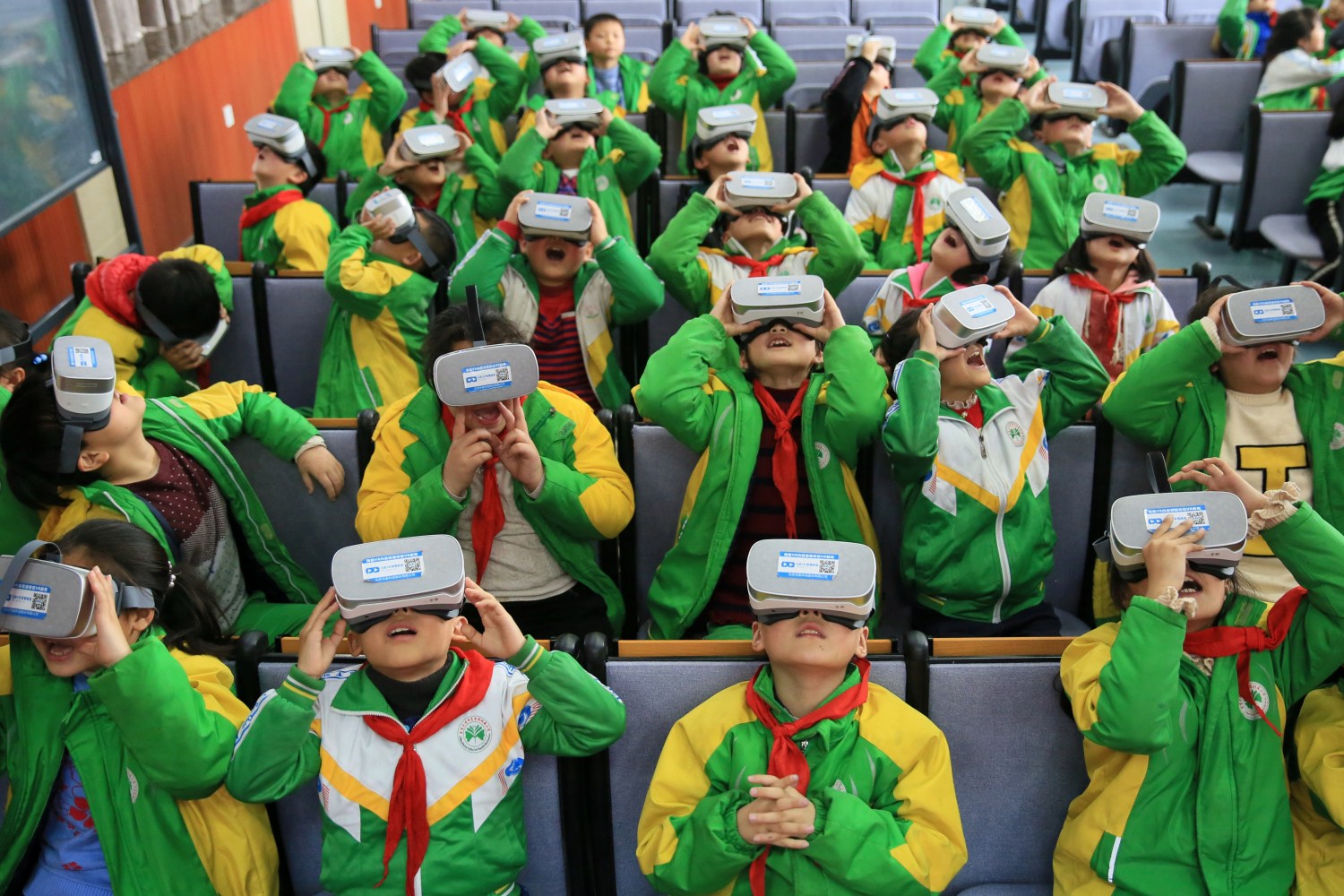 Primary school students wear virtual reality (VR) headsets inside a classroom in Xiangxi Tujia and Miao Autonomous Prefecture, Hunan province, China March 14, 2018. Picture taken March 14, 2018. REUTERS/Stringer  ATTENTION EDITORS - THIS IMAGE WAS PROVIDED BY A THIRD PARTY. CHINA OUT. - RC16E4321880