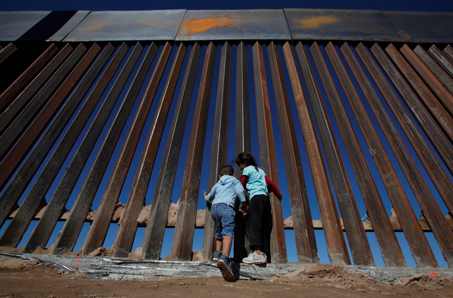 Children play at a newly built section of the U.S.-Mexico border wall at Sunland Park, U.S. opposite the Mexican border city of Ciudad Juarez, Mexico November 18, 2016. Picture taken from the Mexico side of the U.S.-Mexico border. Picture taken November 18, 2016. REUTERS/Jose Luis Gonzalez - RC13C47E2660