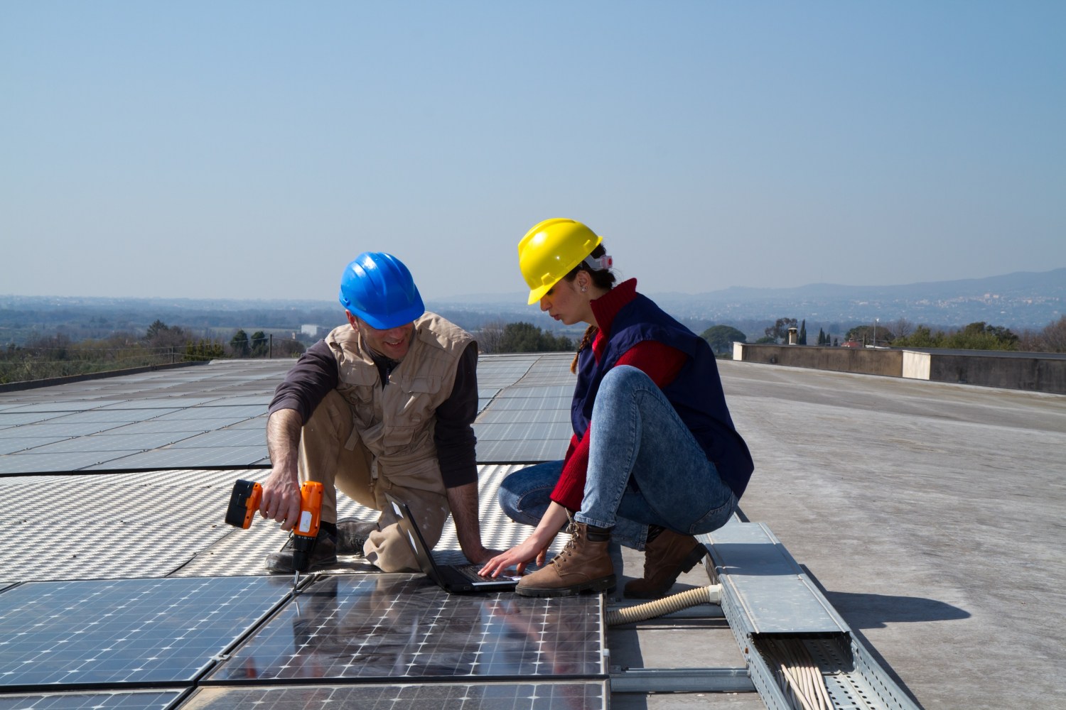 Two clean economy workers installing solar panels