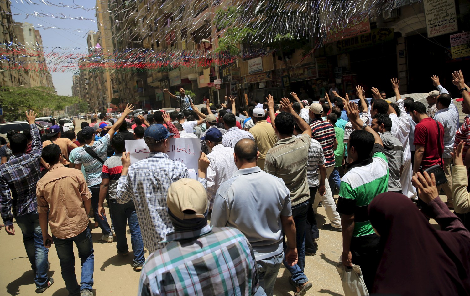 Supporters of the Muslim Brotherhood and deposed Egyptian President Mohamed Mursi shout slogans at a rally against an Egyptian court's decision to sentence Mursi and other leaders to death, as they march under street decoration to mark the holy month of Ramadan in Al Haram street near Giza square, south of Cairo, Egypt June 19, 2015. Mursi will appeal against a conviction for violence, kidnapping and torture imposed by a court over the killing of protesters, his lawyers were quoted as saying by state media on Thursday. REUTERS/Amr Abdallah Dalsh - GF10000133229