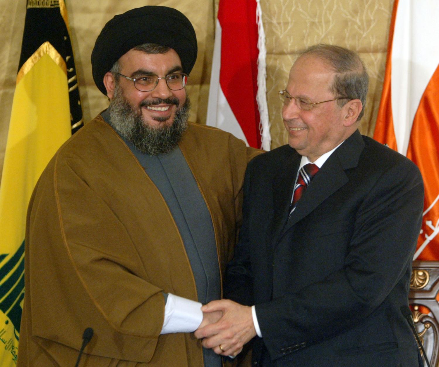 Lebanon's Hizbollah leader Sheikh Hassan Nasrallah (L) shakes hands with compatriot Christian leader Michel Aoun during a news conference in a church in Beirut, Lebanon February 6, 2006. The Chief of Lebanon's Hizbollah joined forces on Monday with Maronite Christian leader Michel Aoun to call for normal diplomatic ties with Syria. REUTERS/Mohamed Azakir - RP3DSFCZIEAB