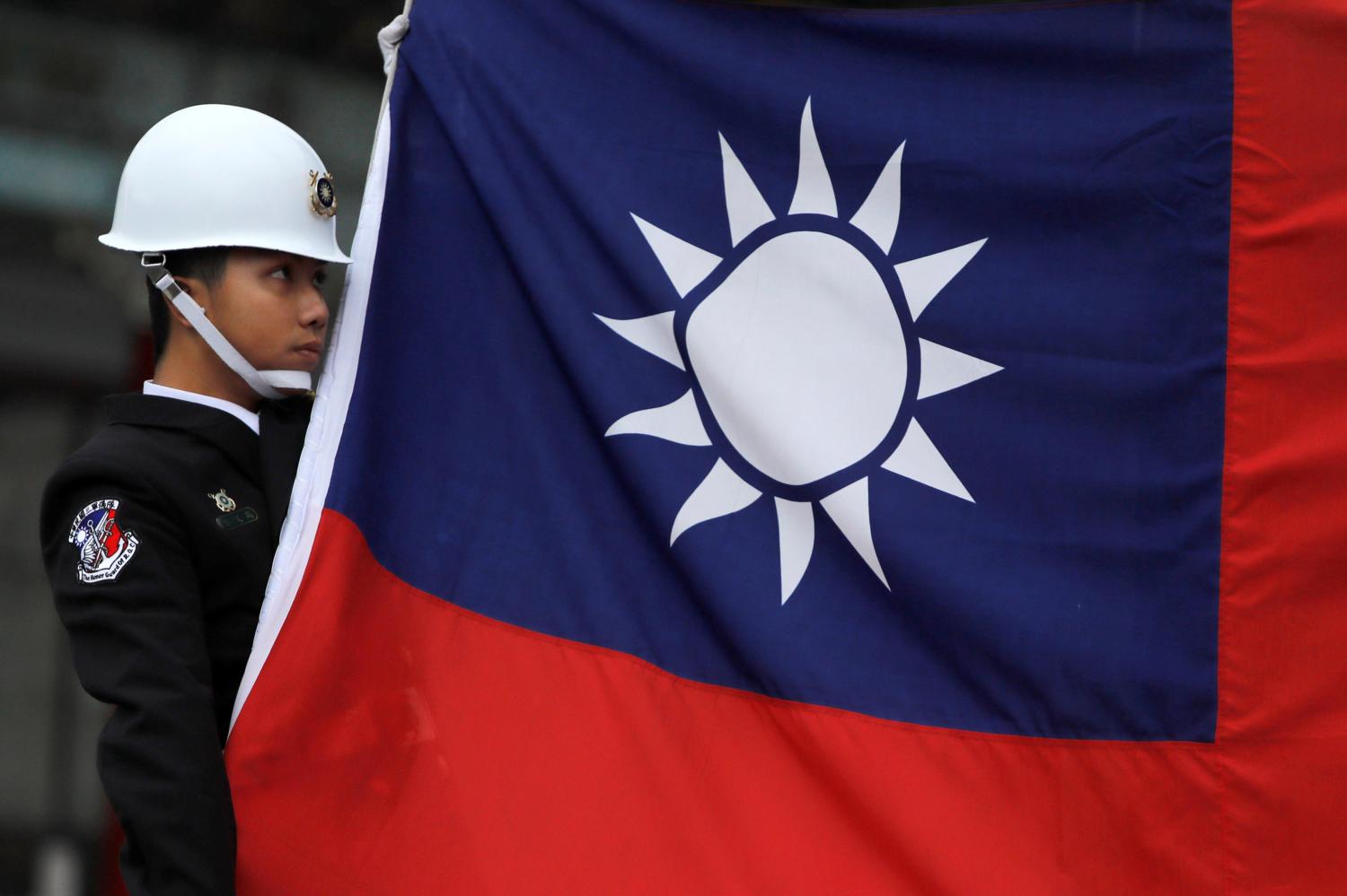 A military honour guard holds a Taiwanese national flag as he attending flag-raising ceremony at Chiang Kai-shek Memorial Hall, in Taipei, Taiwan March 16, 2018. REUTERS/Tyrone Siu - RC1F31B52FB0