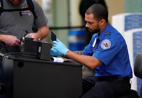 An employee with the Transportation Security Administration (TSA) checks the documents of a traveler at Reagan National Airport in Washington, U.S., January 6, 2019.      REUTERS/Joshua Roberts - RC1299538A70