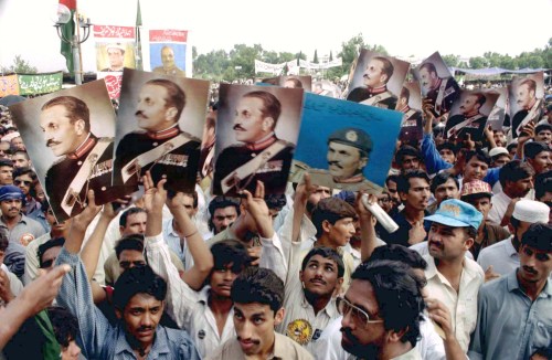 Followers of late Pakistan military ruler General Mohammad Zia-ul-Haq carry his pictures as they assemble at his grave in Islamabad on August 17 to mark his 8th death anniversary. Some 10,000 people took part in the rally and vowed to oust Prime Minister Benazir-Bhutto's government. Zia was killed in a mysterious plane crash in 1988. - PBEAHUMWKBI