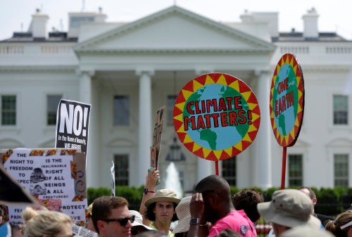 Protesters carry signs during the Peoples Climate March at the White House in Washington, U.S., April 29, 2017. REUTERS/Joshua Roberts