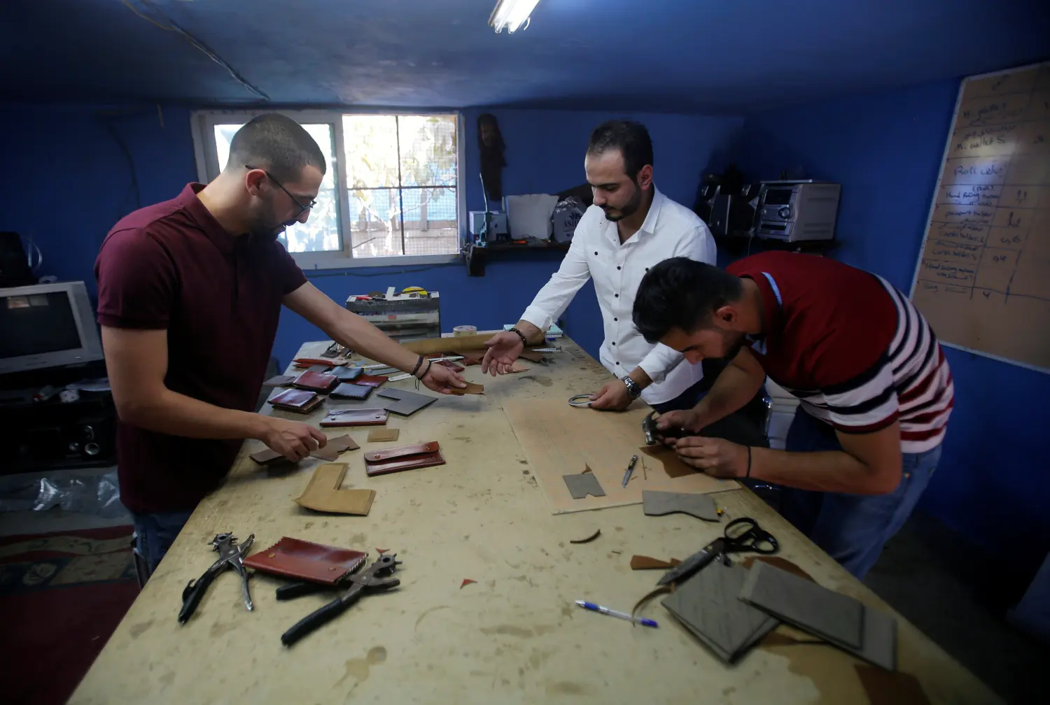 Palestinian men make leather products for sale in a factory in the West Bank town of Dura, south of Hebron July 2, 2017. Picture taken July 2, 2017. REUTERS/Mussa Qawasma -