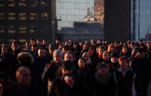 Commuters walk across London Bridge at sunrise in London, Britain, January 19, 2018. REUTERS/Hannah McKay - RC186296E470