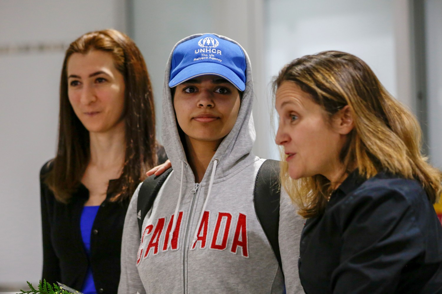 Rahaf Mohammed al-Qunun (C), an 18-year-old Saudi woman who fled her family, accompanied by Canadian Minister of Foreign Affairs Chrystia Freeland (R) and Saba Abbas, general counsellor of COSTI refugee service agency, arrives at Toronto Pearson International Airport in Toronto, Ontario, Canada January 12, 2019.  REUTERS/Carlos Osorio - RC1A167A5FB0