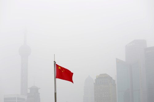Chinese flag is seen in front of the financial district of Pudong amid heavy smog in Shanghai, China, December 23, 2015. REUTERS/Aly Song - D1BESCXWRFAA