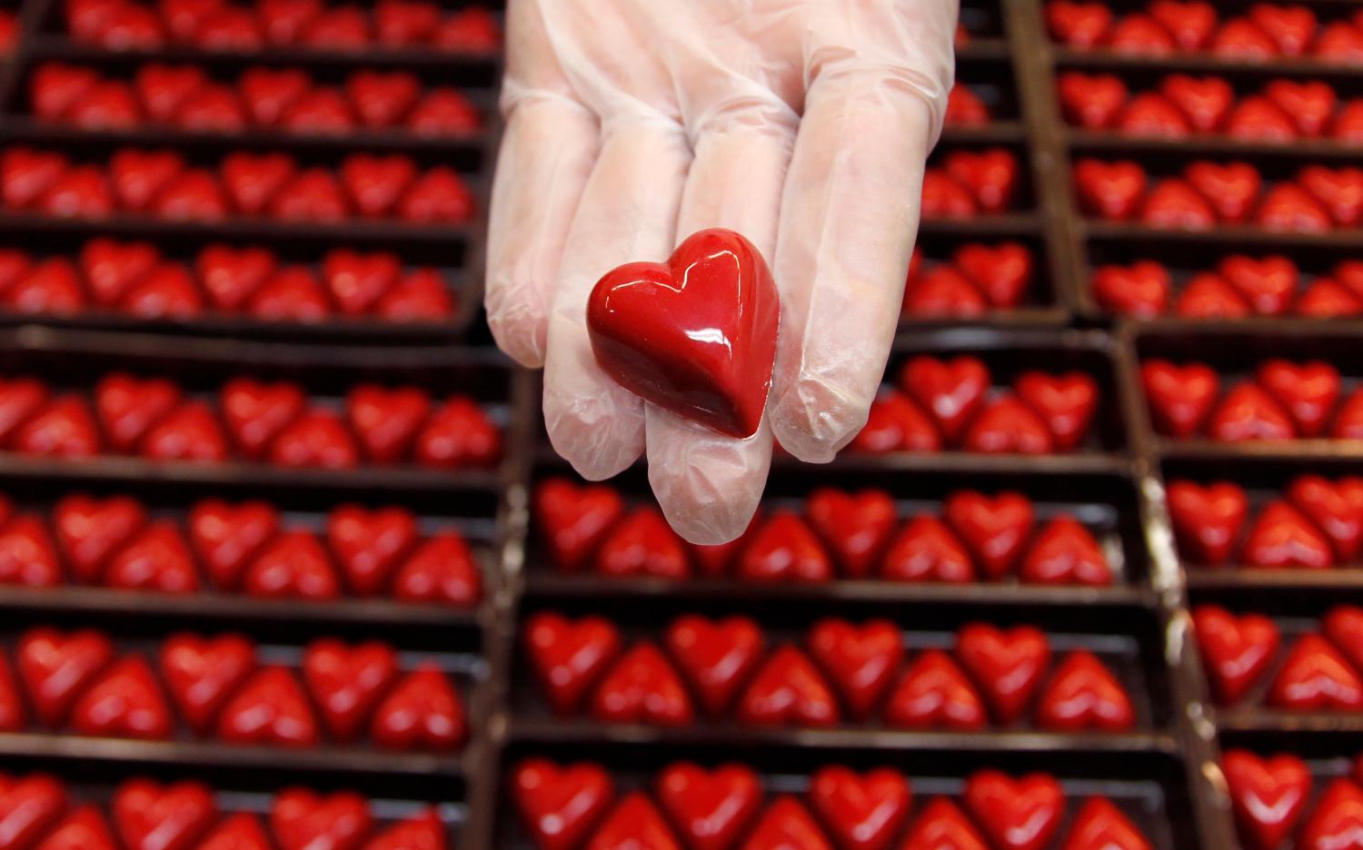 A worker displays a heart-shaped praline for Valentine's Day at a Wittamer chocolate boutique in Brussels February 14, 2012. REUTERS/Francois Lenoir (BELGIUM - Tags: FOOD SOCIETY) - GM1E82E1MJI01