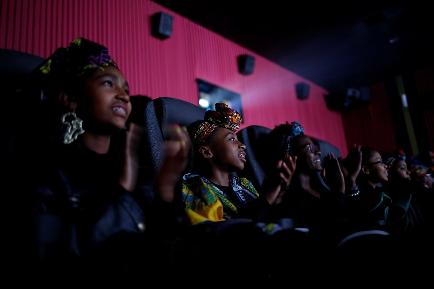 Ron Clark Academy 6th graders applaud during a scene in the film "Black Panther" at Atlantic Station theaters in Atlanta, Georgia, U.S., February 21, 2018. REUTERS/Chris Aluka Berry - RC143EE87A40