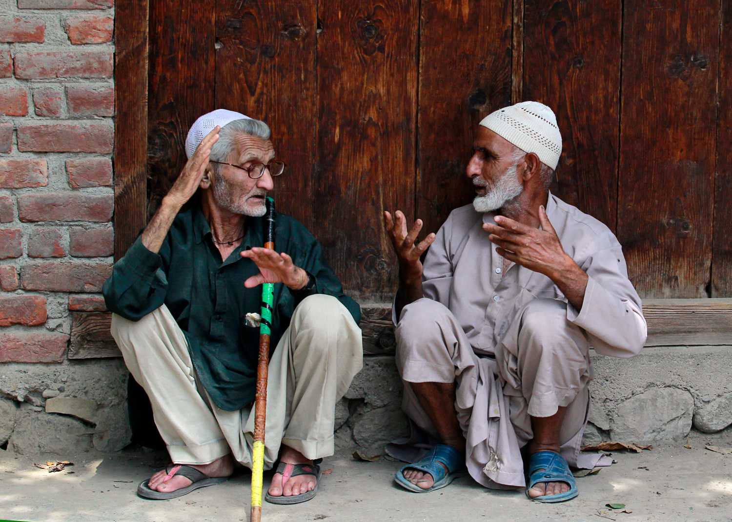 Kashmiri villagers chat in front a close shop as they wait for the body of Aaqib Ahmad Bhat to arrive in Shopian, 60 km (37 miles) south of Srinagar July 31, 2012. Bhat, a 22-year-old youth who was supplying waters in tankers to a camp of India's Central Reserve Police Force (CRPF) and was beaten to death by the CRPF personnel after an argument over some issue, said the relatives and villagers. However, the police said that Bhat was killed in a road accident and are investigating the matter.  REUTERS/Fayaz Kabli     (INDIAN-ADMINISTERED KASHMIR - Tags: SOCIETY) - GM1E87V1JM101