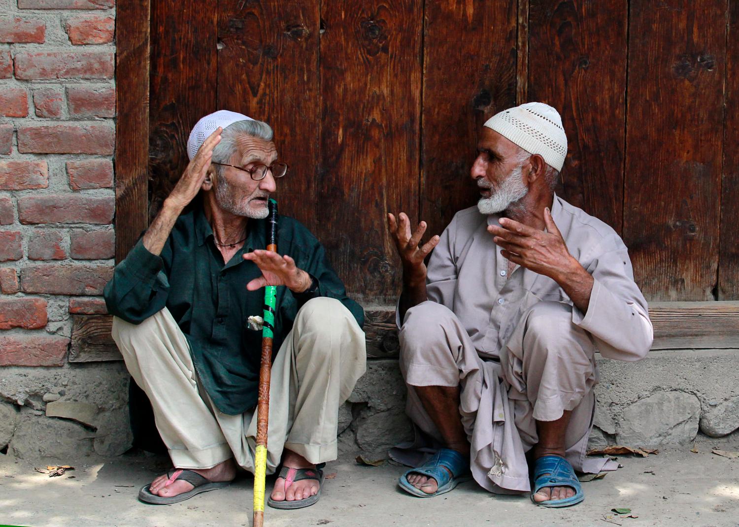 Kashmiri villagers chat in front a close shop as they wait for the body of Aaqib Ahmad Bhat to arrive in Shopian, 60 km (37 miles) south of Srinagar July 31, 2012. Bhat, a 22-year-old youth who was supplying waters in tankers to a camp of India's Central Reserve Police Force (CRPF) and was beaten to death by the CRPF personnel after an argument over some issue, said the relatives and villagers. However, the police said that Bhat was killed in a road accident and are investigating the matter.  REUTERS/Fayaz Kabli     (INDIAN-ADMINISTERED KASHMIR - Tags: SOCIETY) - GM1E87V1JM101