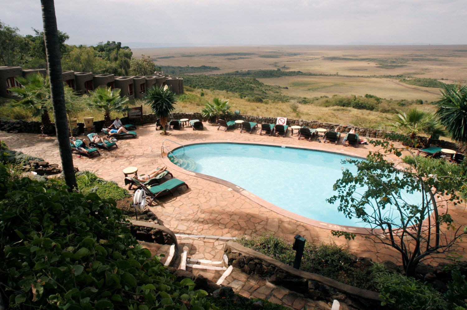 Tourists are seen by the poolside of the Mara Serena Safari Lodge, within the Masai Mara game reserve, southwest of Nairobi, Kenya, July 28, 2009. Picture taken July 28, 2009. REUTERS/Thomas Mukoya     TPX IMAGES OF THE DAY - RC1B60ECDBC0