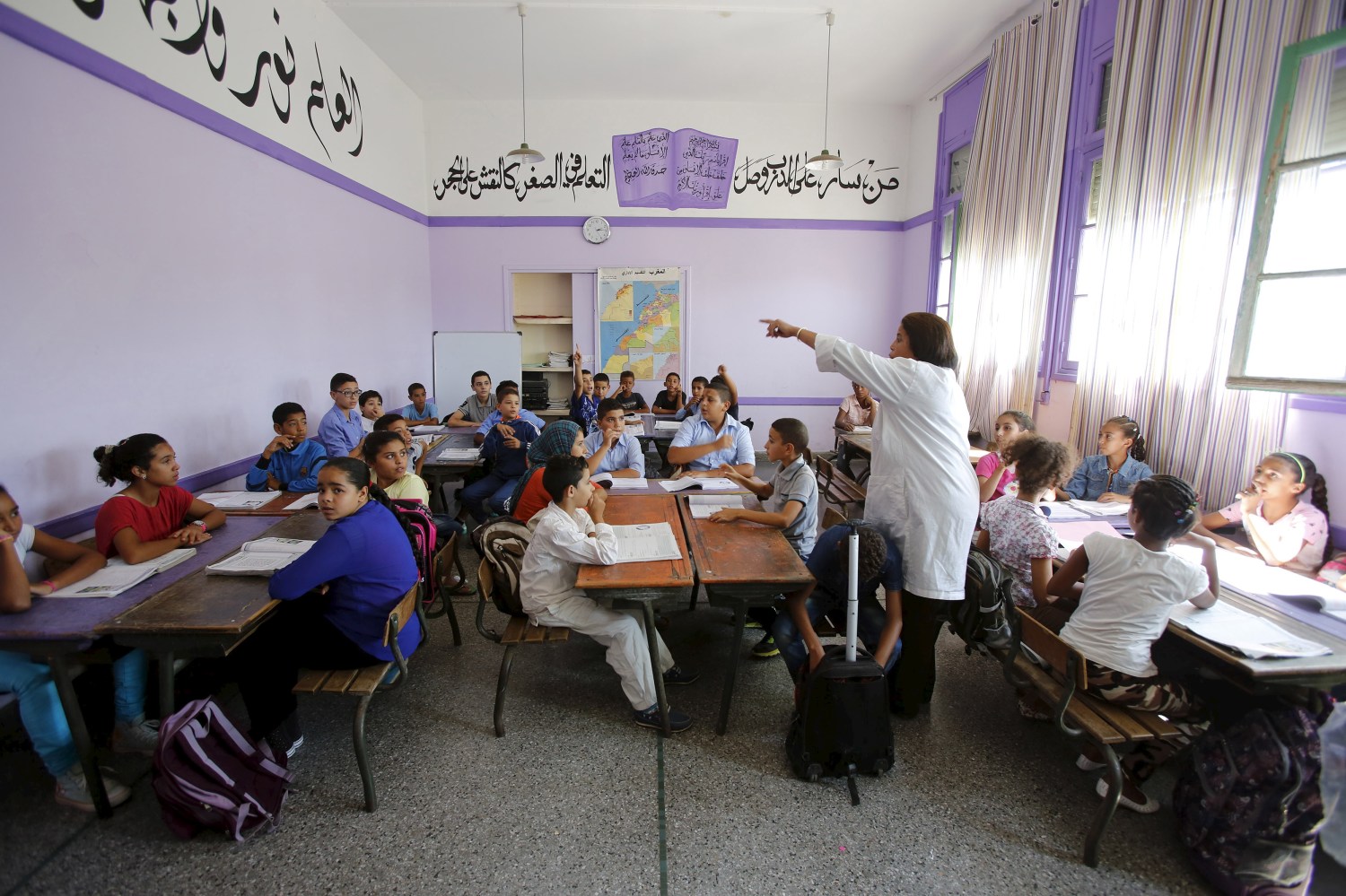 Schoolchildren listen to a teacher as they study during a class in the Oudaya primary school in Rabat, September 15, 2015, at the start of the new school year in Morocco. Nearly three years after Taliban gunmen shot Pakistani schoolgirl Malala Yousafzai, the teenage activist last week urged world leaders gathered in New York to help millions more children go to school. World Teachers' Day falls on 5 October, a Unesco initiative highlighting the work of educators struggling to teach children amid intimidation in Pakistan, conflict in Syria or poverty in Vietnam. Even so, there have been some improvements: the number of children not attending primary school has plummeted to an estimated 57 million worldwide in 2015, the U.N. says, down from 100 million 15 years ago. Reuters photographers have documented learning around the world, from well-resourced schools to pupils crammed into corridors in the Philippines, on boats in Brazil or in crowded classrooms in Burundi.  REUTERS/Youssef BoudlalPICTURE 40 OF 47 FOR WIDER IMAGE STORY "SCHOOLS AROUND THE WORLD"SEARCH "EDUCATORS SCHOOLS" FOR ALL IMAGES - GF10000226473