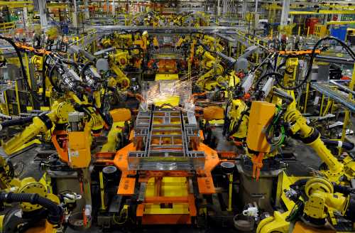 Robotic arms spot welds on the chassis of a Ford Transit Van under assembly at the Ford Claycomo Assembly Plant in Claycomo, Missouri April 30, 2014.  REUTERS/Dave Kaup  (UNITED STATES - Tags: BUSINESS TRANSPORT) - GM1EA510A6N01