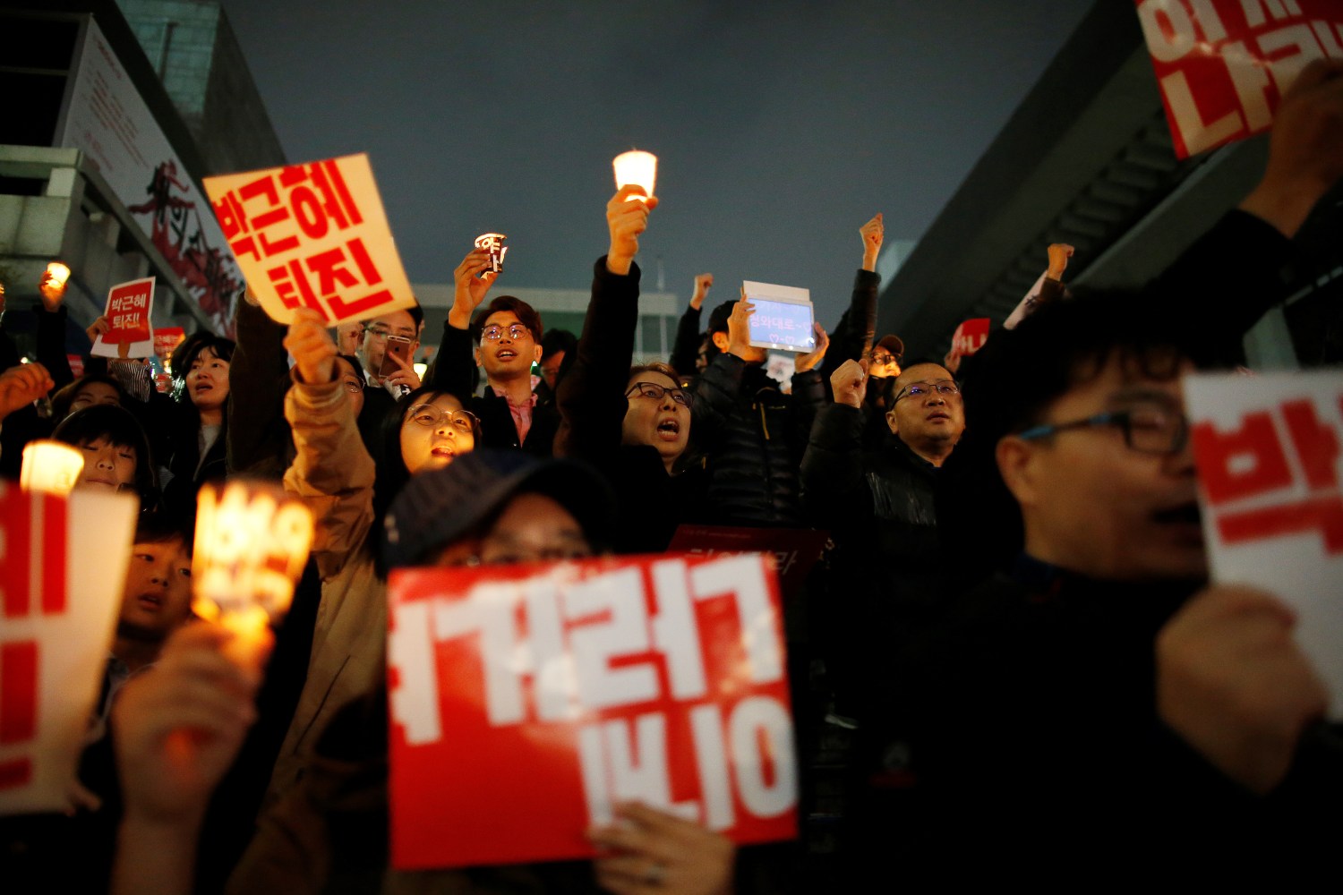 South Korean people chant slogans during a rally calling on embattled President Park Geun-hye to resign over a growing influence-peddling scandal in central Seoul, South Korea, November 5, 2016. The placards read, "Step down Park Geun-hye". REUTERS/Kim Hong-Ji - S1AEULBVVAAA
