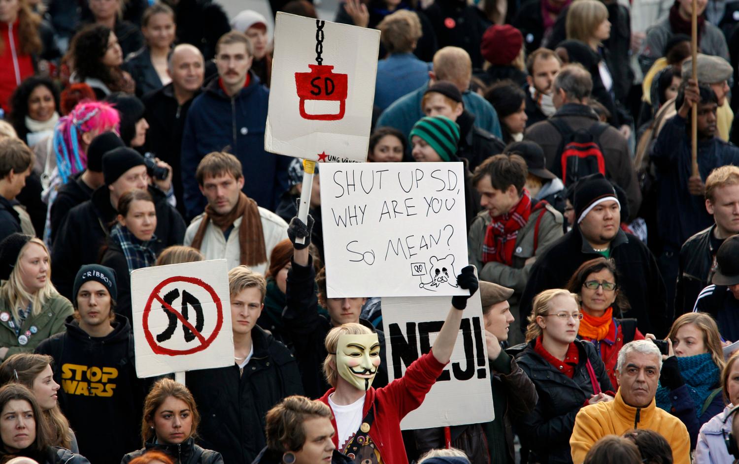 Protestors carry signs against the right-wing Sweden Democrat party during a demonstration against anti-immigration politics in downtown Stockholm October 4, 2010. REUTERS/Bob Strong (SWEDEN - Tags: POLITICS CIVIL UNREST SOCIETY) - GM1E6A502DM01