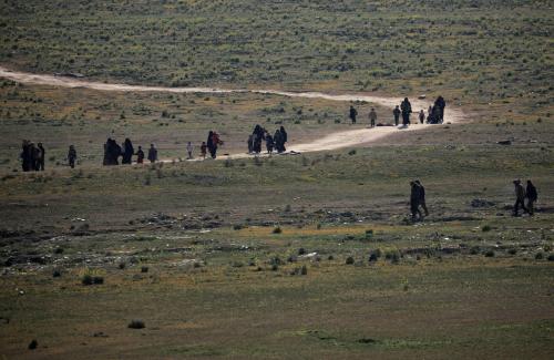 Women and children walk with their belongings near Baghouz, Deir Al Zor province, Syria February 12, 2019. Picture taken February 12, 2019. REUTERS/ Rodi Said - RC1B2727B0D0